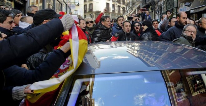 El concejal de Salud, Seguridad y Emergencias de Madrid, Javier Barbero (d), a la salida hoy de las dependencias municipales, se introduce en un coche mientras es increpado por los asistentes a una concentración de policías municipales, en los alrededores