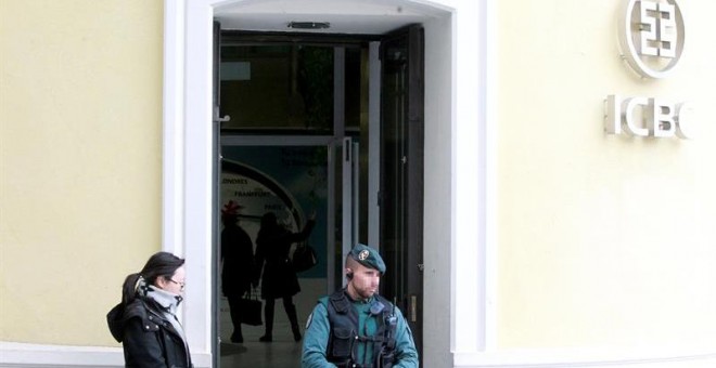 Un agente de la Guardia Civil controla ayer por la tarde la entrada a la sede del banco chino ICBC, en el centro de Madrid. /EFE