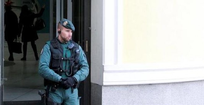 Un agente de la Guardia Civil controla ayer por la tarde la entrada a la sede del banco chino ICBC, en el centro de Madrid. /EFE