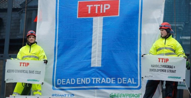 Miembros de Greenpeace y activistas medioambientales bloquean la entrada de la sede de la Unión Europea durante una protesta en contra del acuerdo de libre comercio TTIP entre la Unión Europea y Estados Unidos en Bruselas.- EFE
