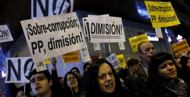 Manifestantes protestando contra la corrupción en el PP, en una concentración frente a la sede nacional del partido, en la madrileña calle de Génova, en  febrero de 2014. REUTERS/Susana Vera