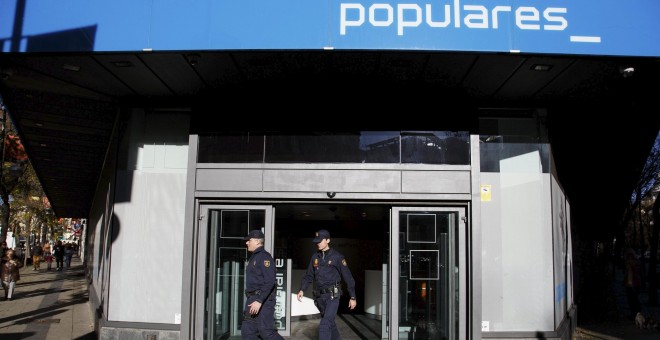 Dos agentes de Policía salen de la sede del PP en la madrileña calle de Génova, tras el registro realizado en diciembre de 2013 durante 14 horas en busca de documentación sobre el pago en B de las obras del edificio, en . REUTERS/Paul Hanna