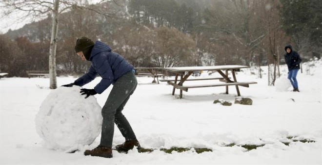 Un niño juega con la nieve en un área recreativa próxima a la localidad de Robledondo, en la sierra norte de Madrid. / BALLESTEROS (EFE)