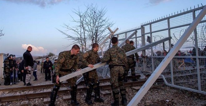 Polcías macedonios cierran la puerta abierta para los trenes internacionales, en la frontera con Grecia, cerca de la localidad macedonia de Gevgelija