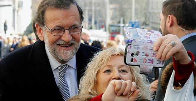 Mariano Rajoy se hace un 'selfie' con una mujer a la salida este miércoles del Congreso. - EFE