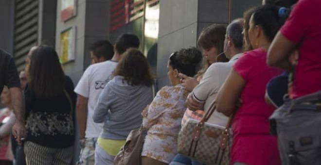 Varias mujeres esperan en la cola del paro. EFE