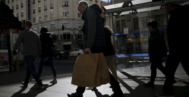 Varias personas con las bolsas de sus compras por el centro de Madrid. REUTERS/Andrea Comas