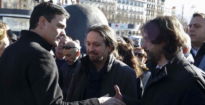 El secretario general del PSOE, Pedro Sánchez (i), saluda al responsable de Relaciones con la Sociedad Civil de Podemos, Rafael Mayoral, en presencia del líder de la formación, Pablo Iglesias, durante el homenaje.- EFE