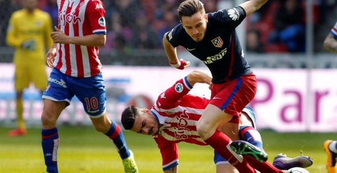 El centrocampista del Sporting Sergio Álvarez (d) y el centrocampista del Atlético de Madrid Saúl Ñíguez durante el partido de la trigésima jornada de Liga que disputan en el estadio del Molinón, en Gijón. /EFE