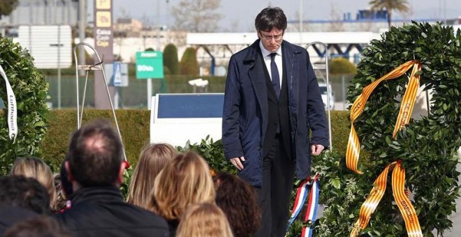 El presidente de la Generalitat, Carles Puigdemont, tras la ofrenda floral que realizó al final del acto de homenaje a las víctimas del accidente del vuelo Germanwings 9525, que ha presidido hoy junto al jefe del Ejecutivo, Mariano Rajoy, en el aeropuerto
