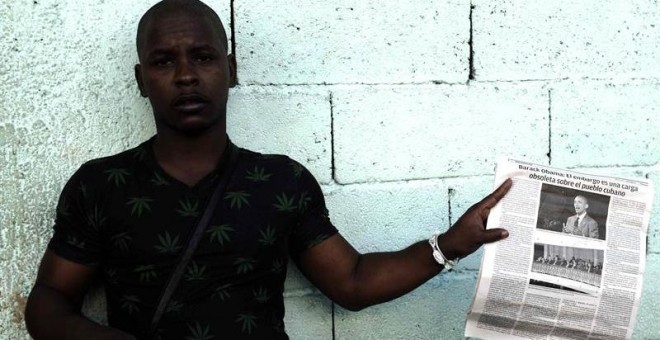 Un hombre sostiene un diario con información del presidente de EEUU, Barack Obama, en una calle de La Habana.- EFE