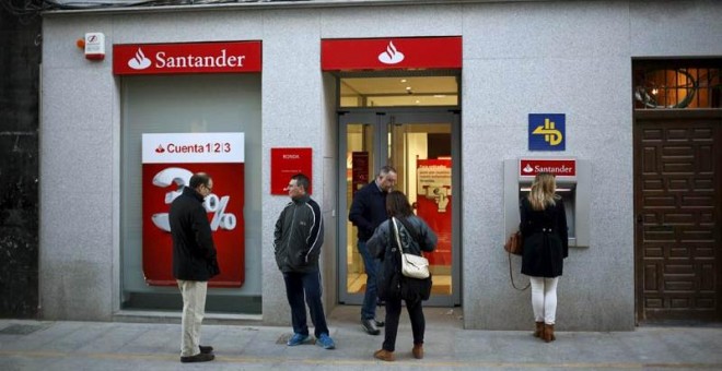 Varios clientes aguardan a que abra una oficina del Banco Santander en Ronda. / REUTERS