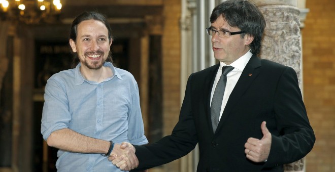 El presidente de la Generalitat, Carles Puigdemont, saluda al líder de Podemos, Pablo Iglesias, con quien se ha reunido esta tarde en el Palau. EFE/Andreu Dalmau.