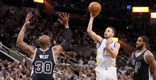 Stephen Curry, de los Warriors, lanza a canasta ante David West, de los Spurs. /REUTERS