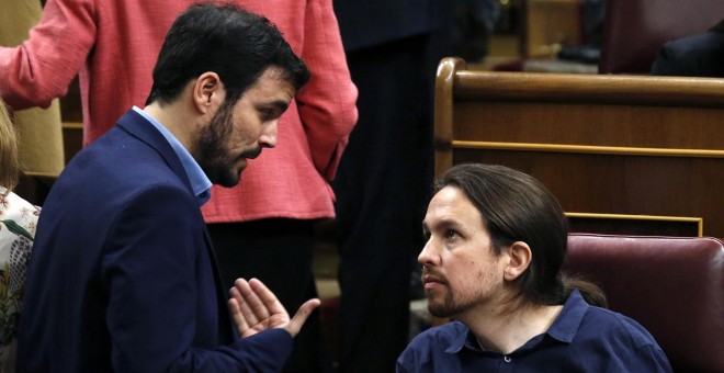 El diputado de IU-Unidad Popular, Alberto Garzón, conversa con el líder de Podemos, Pablo Iglesias, durante la sesión constitutiva del Congreso.-REUTERS