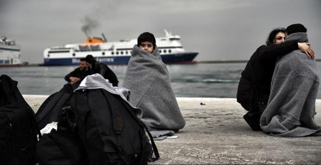 Un niño refugiado cubierto con mantas en el puerto de Mitilene, en Lesbos. ARIS MESSINIS / AFP