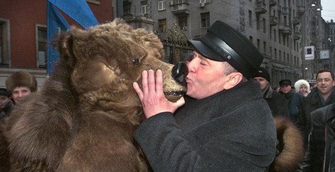 El líder del partido ultranacionalista ruso Liberal-Democrático Vladimir Zhirinovsky besa a un ruso vestido de oso durante una manifestación por el Día de la Constitución de Rusia en Moscú en 1999.- ALEXANDER NEMENOV / AFP