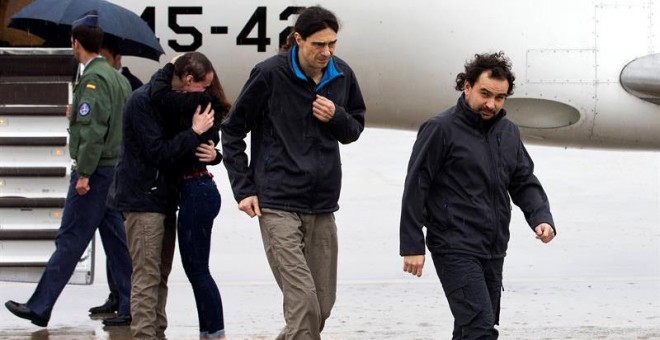 Ángel Sastre, José Manuel López y Antonio Pampliega (abrazando a un familiar) a su llegada a la Base äerea de Torrejón de Ardoz, en Madrid. - EFE