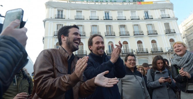 Alberto Garzón, líder de Izquierda Unida, y Pablo Iglesias, secretario general de Podemos, escenifican su acuerdo electoral en la Puerta del Sol de Madrid. PODEMOS