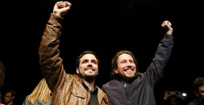 Los líderes de Podemos, Pablo Iglesias, y de Izquierda Unida, Alberto Garzón, salen de la sala Mirador, donde celebran un encuentro ciudadano, para atender a los medios tras el preacuerdo electoral alcanzado por ambas formaciones para presentarse a los c