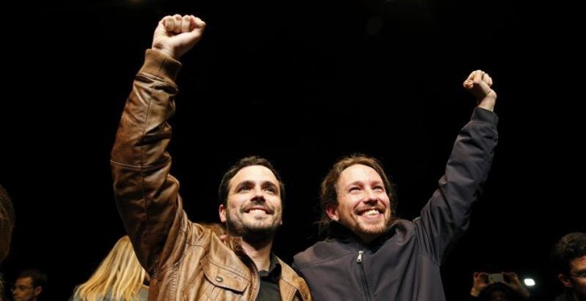 Los líderes de Podemos, Pablo Iglesias, y de Izquierda Unida, Alberto Garzón, salen de la sala Mirador, donde celebran un encuentro ciudadano, para atender a los medios tras el preacuerdo electoral alcanzado por ambas formaciones para presentarse a los c