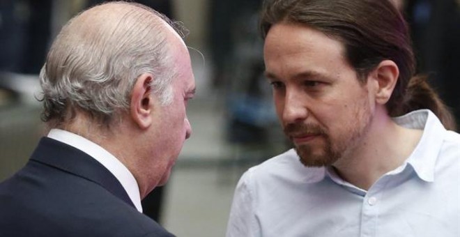 El líder de Podemos, Pablo Iglesias, conversa con el ministro de Interior en funciones, Jorge Fernández Díaz. - EFE