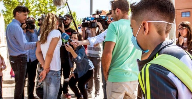Padres del colegio Juan Carlos I en Seseña, atienden a los medios de comunicación, a su llegada a la recogida del alumnado con máscaras protectoras. /EFE