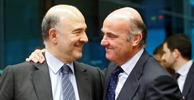 El comisario europeo de Asuntos Económicos, Pierre Moscovici, (i), conversa con el ministro español en funciones de Economía, Luis de Guindos (d) durante la reunión del Eurogrupo celebrada hoy en Bruselas.-  EFE/Olivier Hoslet