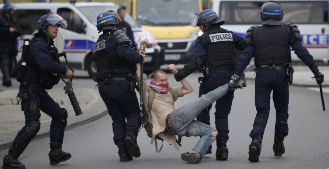 La Policía detiene a un joven durante las protestas contra la reforma laboral.- REUTERS