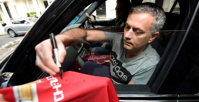 Mourinho firma autógrafos a los aficionados del United. / REUTERS