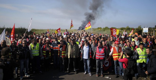 Empleados de sindicatos franceses CGT en huelga se colocan cerca de una barricada en llamas antes de una operación policial para liberar un depósito de combustible en Donges, Francia.- REUTERS / Stephane Mahe