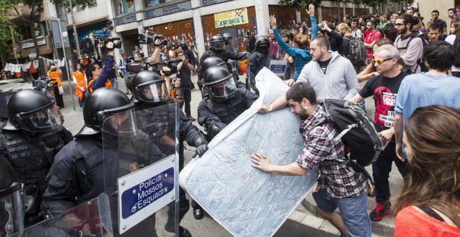 Agentes antidisturbios de los Mossos rodean los accesos del 'Banc Expropiat' de Barcelona tras dispersar a empujones al centenar de personas que se habían concentrado a las puertas de la finca, en apoyo a los okupas. EFE/Quique García