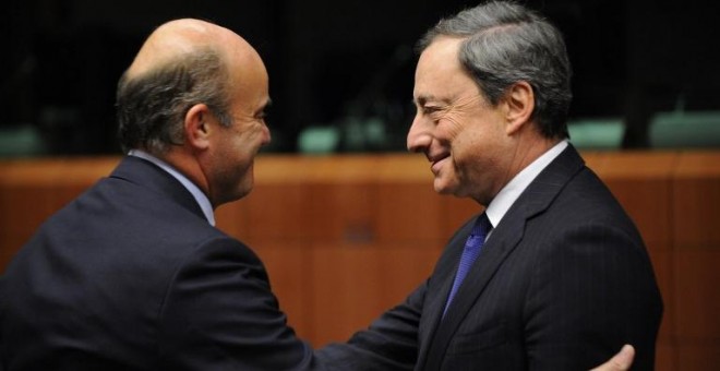 El ministro de Economía, Luis de Guindos, saluda al presidente del BCE, Mario Draghi, en una reunión del Eurogrupo en Bruselas. AFP/ JOHN THYS