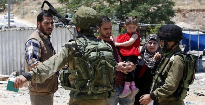Soldados israelíes impide la entrada a una familia palestina a la ciudad cisjordana de Yatta. - EFE