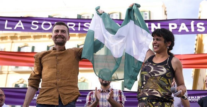 La secretaria general de Podemos en Andalucía, Teresa Rodríguez, y el coordinador general de IU, Antonio Maillo (i), saludan a los simpatizantes durante el mitín electoral de Unidos Podemos que se esta llevando a cabo en la plaza de la Merced, en Málaga.