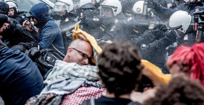 Agentes de Policía lanzan chorros de agua a presión contra manifestantes en Viena. /EFE