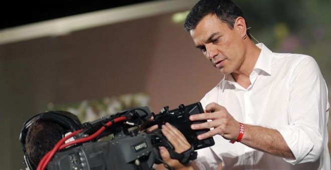 El candidato del PSOE a la Presidencia del Gobierno, Pedro Sánchez, firma sobre el objetivo de una cámara el documento que recoge sus principales medidas durante el mitin de hoy en Oviedo. EFE/ José Luis Cereijido.