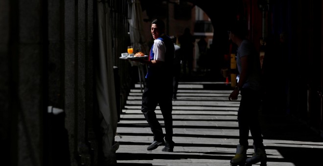 Un camarero con su bandeja en los soportales de la Plaza Mayor de Madrid. REUTERS/Sergio Perez