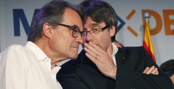 El presidente de la Generalitat, Carles Puigdemont (d), conversa con el líder de CDC, Artur Mas (i), en la sede electoral de CDC en la noche del 26J. /EFE