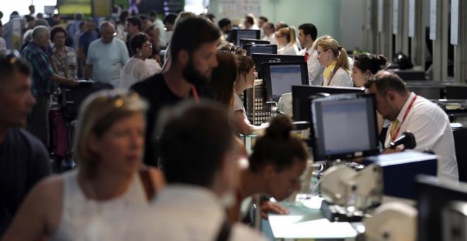 Personal de facturación de Vueling atiende a los viajeros en el Aeropuerto de El Prat, después de que la aerolínea haya cancelado esta mañana una decena de vuelos con destino u origen Barcelona y que la mayoría de rutas acumulen retrasos, algunos de hasta