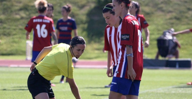 Marta Frías señala la línea de una barrera.