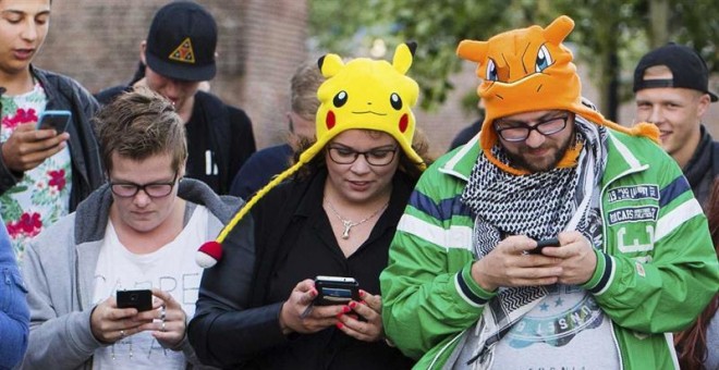 Un grupo de personas mientras juegan al videojuego "Pokémon Go" con sus móviles, en Leerdam, Holanda. EFE/Piroschka Van De Wouw