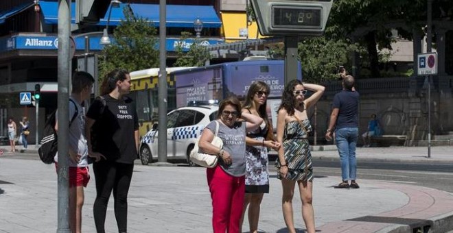 Varias personas ante un termómetro que marca 48 grados en una calle de Ourense. - EFE