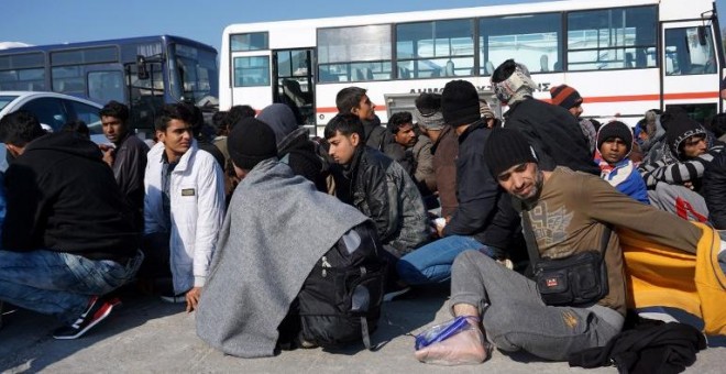 Migrantes y refugiados esperan a ser recogidos en autobuses para entrar en el 'hotspot' de Moria, en Grecia. - AFP