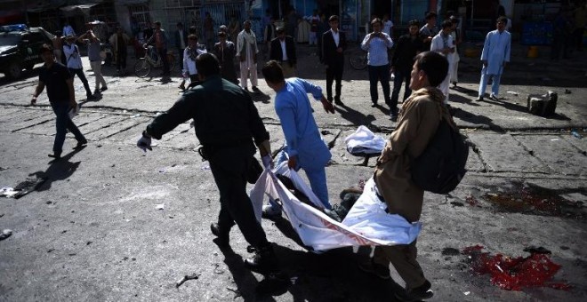 Varias personas trasladan el cuerpo de una de las víctimas del atentado. - AFP