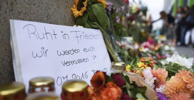 Flores y velas para recordar a las víctimas frente al centro comercial donde el viernes se produjo el ataque en Munich. EFE