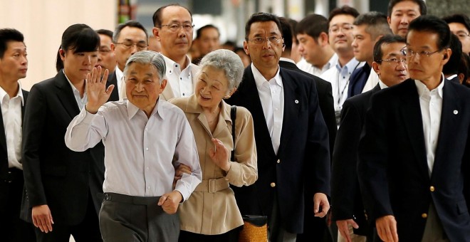 El emperador de Japón Akihito, con la emperatriz Michiko, saluda antes subir al tren bala que lo llevó el pasado julio a su residencia de verano en Nasu. REUTERS/Issei Kato