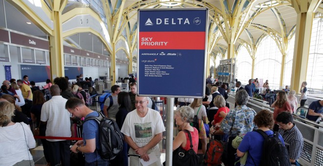 Varios pasajeros esperan en la cola de facturación de la aerolínea Delta tras la avería en el sistema informático de la compañía. REUTERS/Joshua Roberts