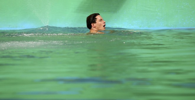 El saltador aleman Patrick Hausding, en la piscina olímpica con las el agua teñida de verde. REUTERS/Marcos Brindicci
