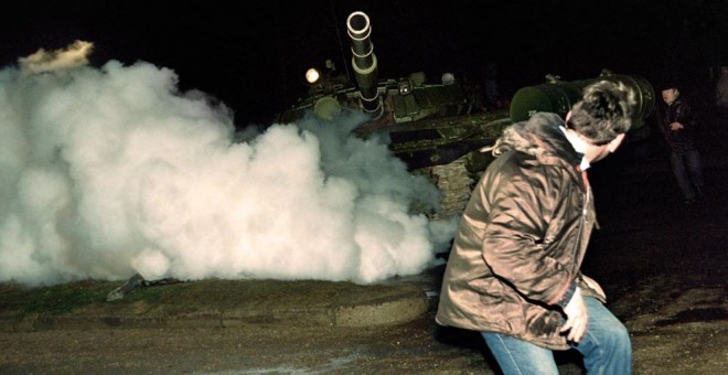 Un manifestante lituano corre frente a un tanque del ejército soviético durante el asalto a la estación de radio y televisión lituana el 13 de enero de 1991. AFP